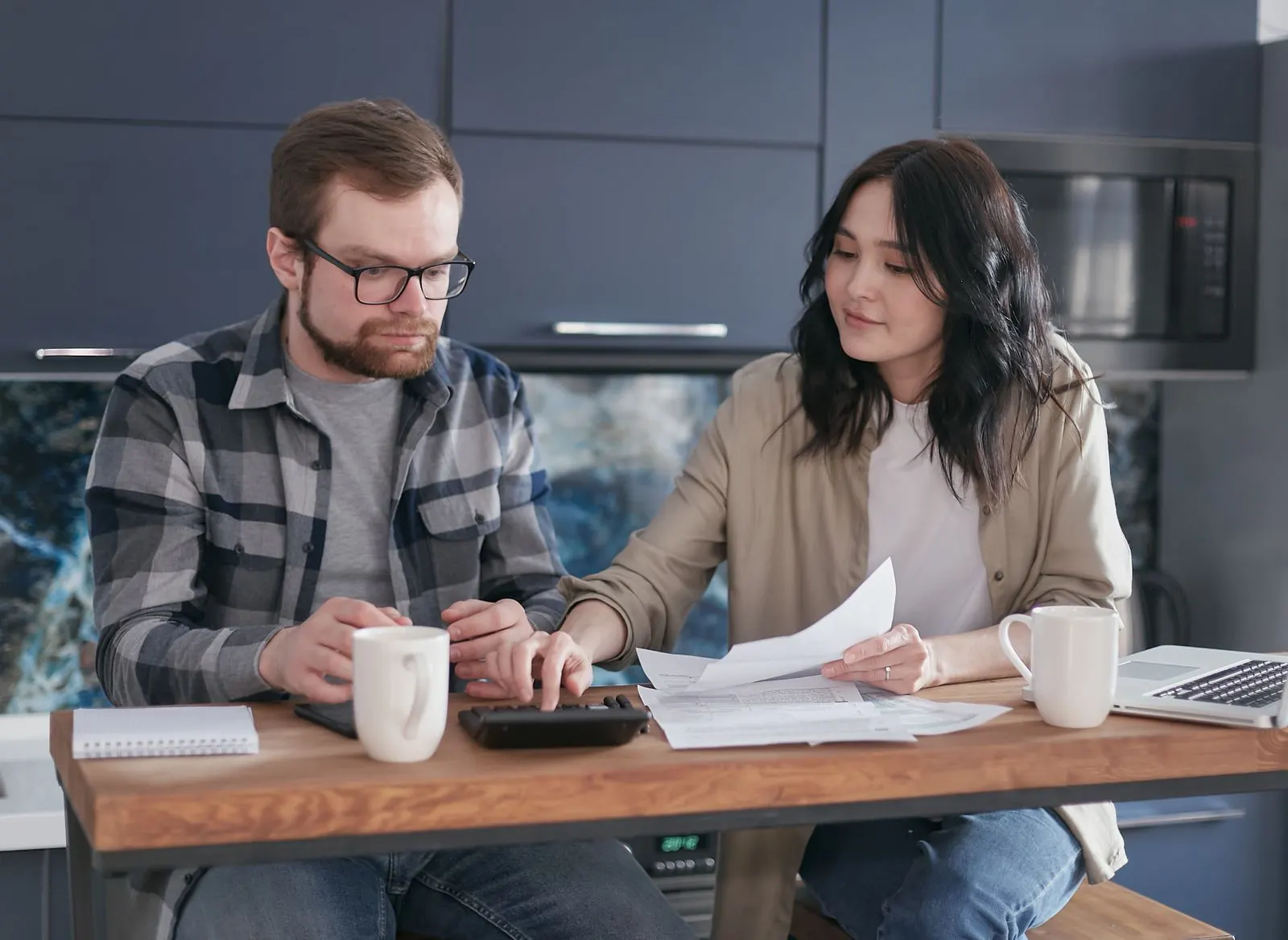 Couple sorting through bills together at home to plan their budget