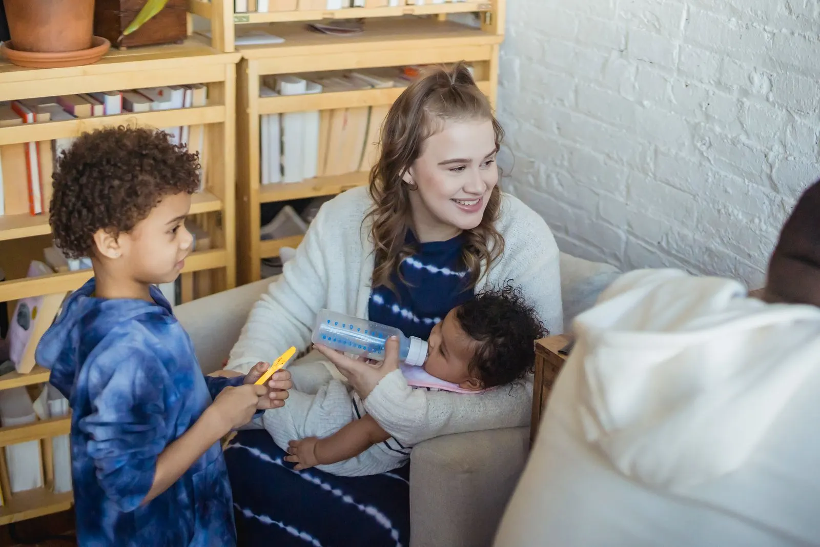 Mother on a sofa at home with her young children